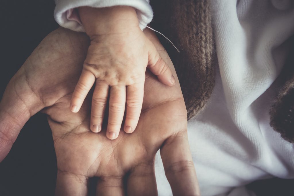 A baby's hand in a grown-ups palm